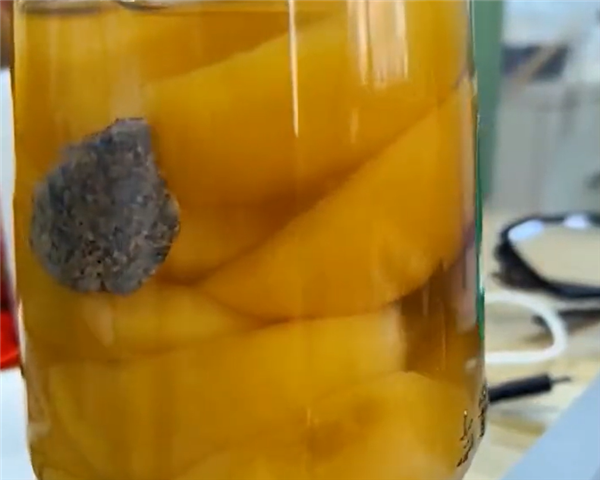 网友发现黄桃罐头里面有石头 厂家：是麦饭石、可增加微量元素